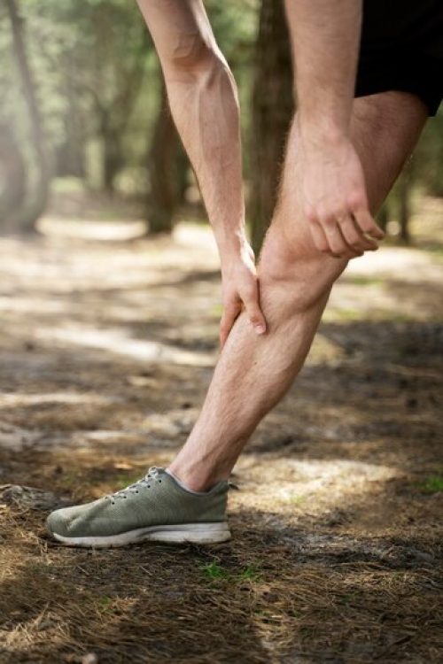 side-view-man-stretching-leg-outdoors_23-2149436719